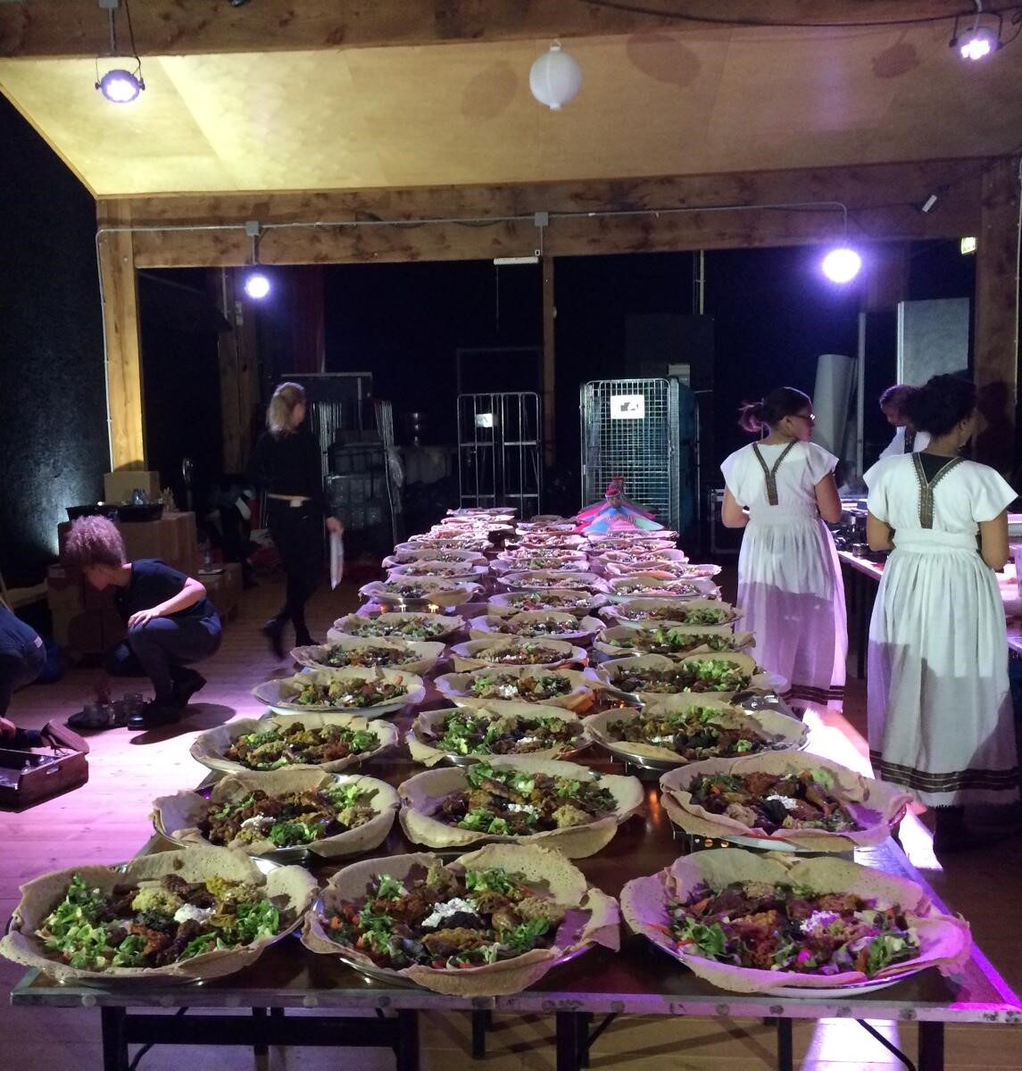 Lange tafel vol enjera-schalen tijdens een catering
