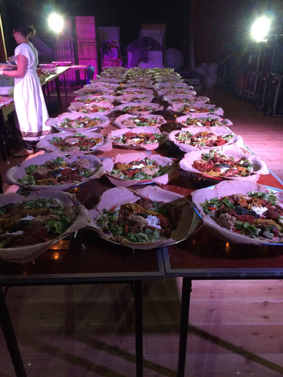 Cateringtafel met schalen en bediening in traditionele kleding