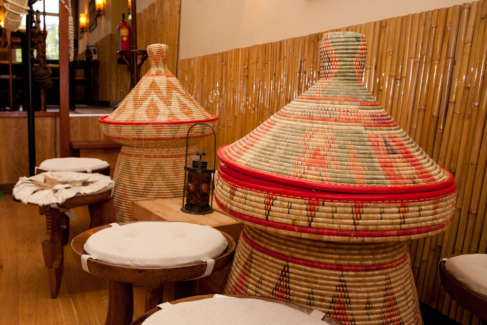 Interieur met bamboe en traditionele mesob-tafels